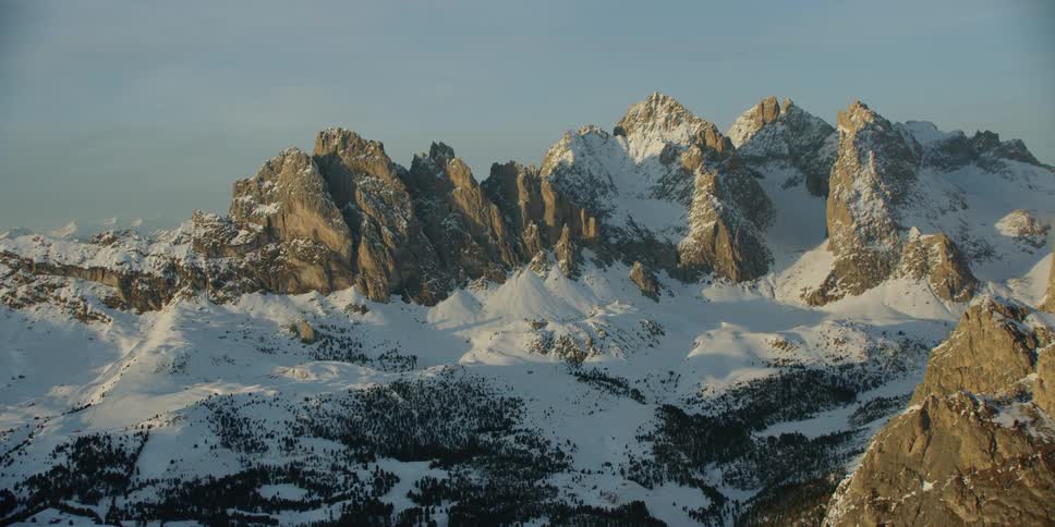 A mountain area covered in snow on a cloudy day
