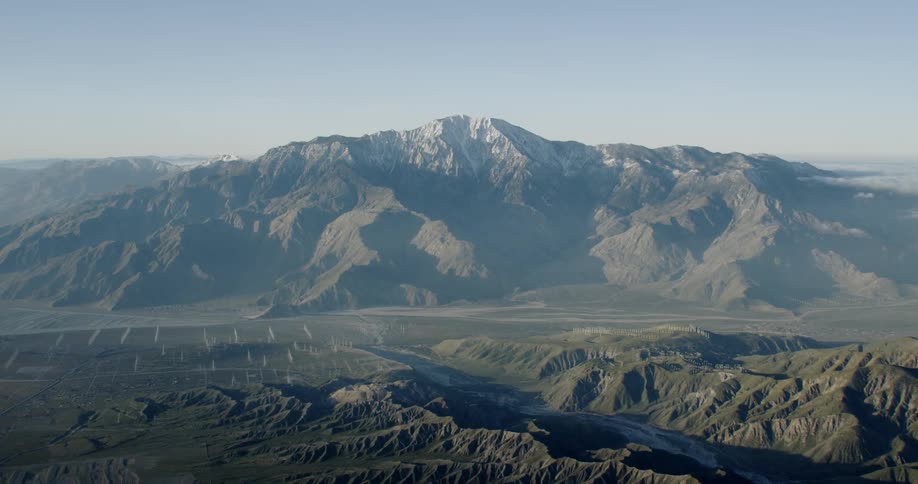 Wind Turbines and a snow capped desert mountain