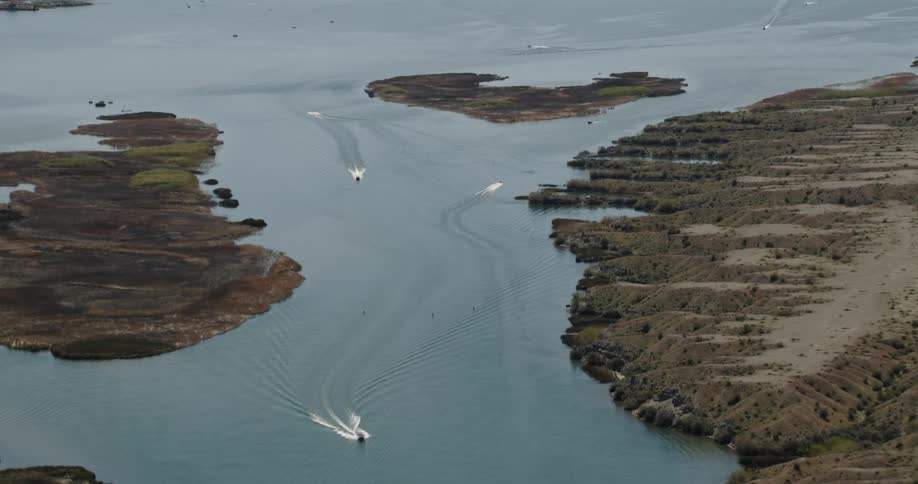 Boats traveling on body of water during the day