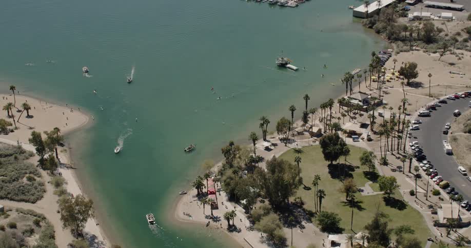 Boats are making their way along a beach near Lake Havasu City