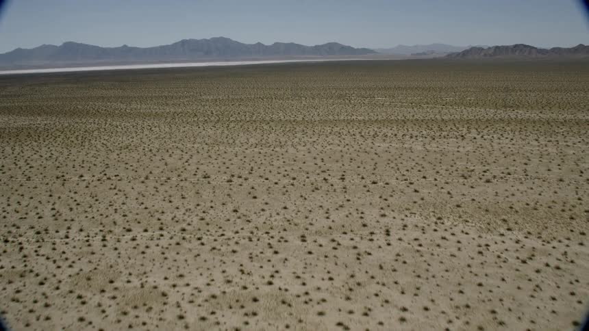 A vast desert landscape rises up to the mountains