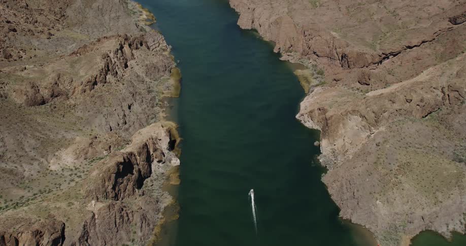 A lone motor boat navigates through the Colorado River