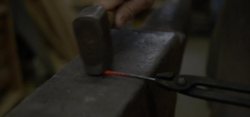 A person is hammering on an anvil