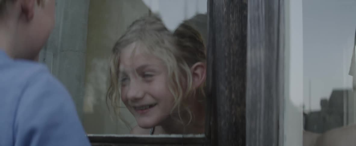 A girl and boy play next to a window