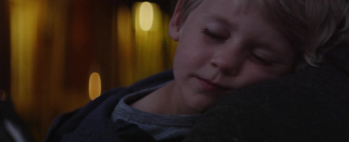 A child is sleeping in a parents arms