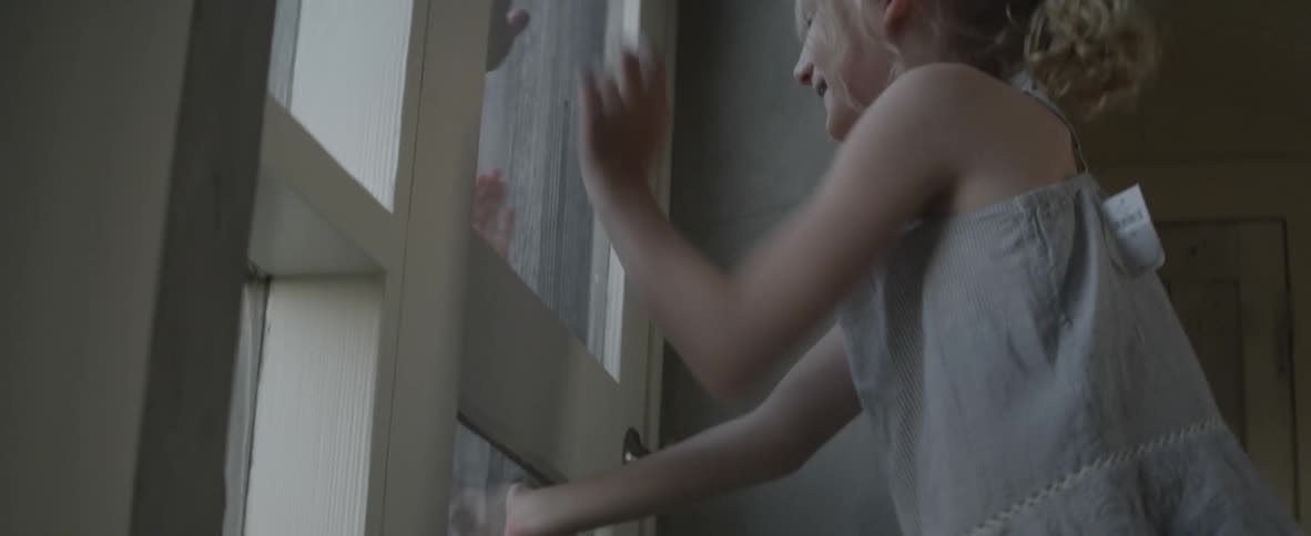 A child is playing through a window with another child