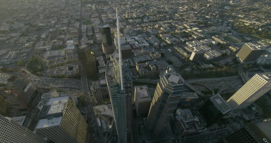 Sunlight falling on skyscrapers as traffic flows through a city