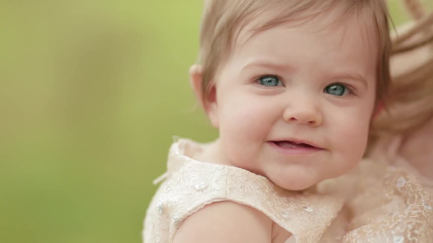 Child smiles as a woman holds her