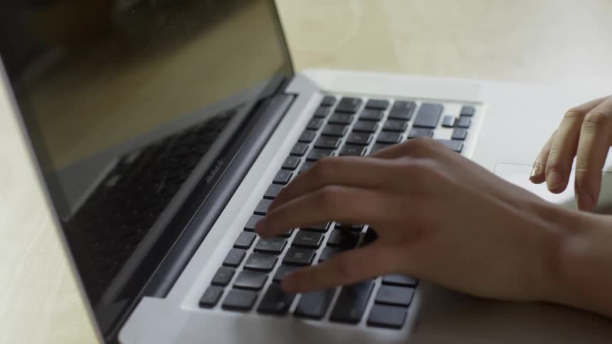 Someone works at a laptop