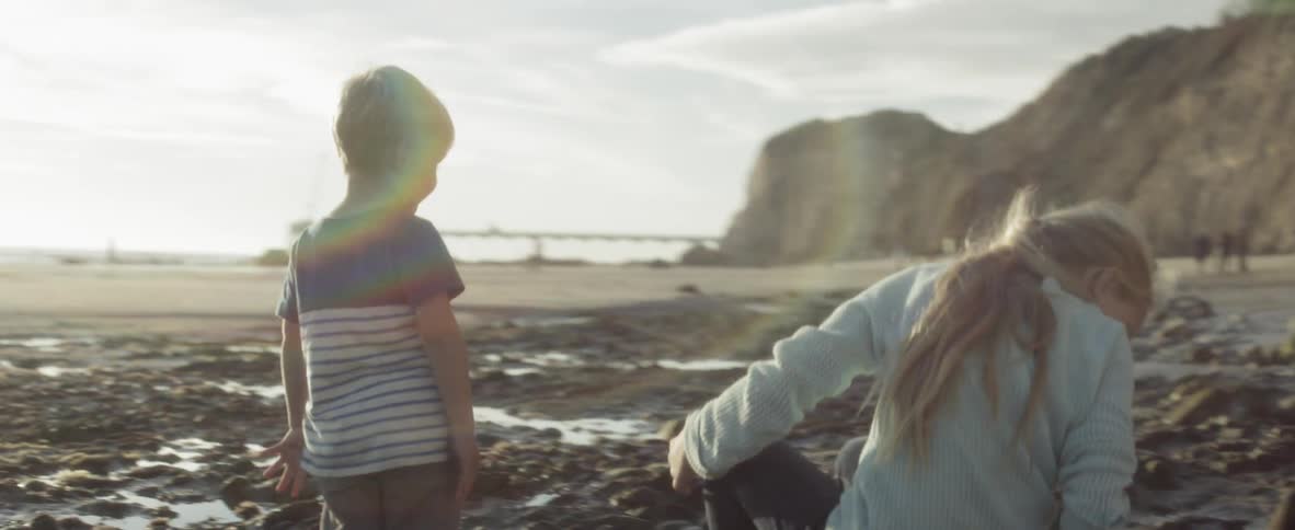 Kids play on a rocky beach