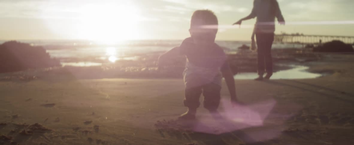 A mother and child play on the beach