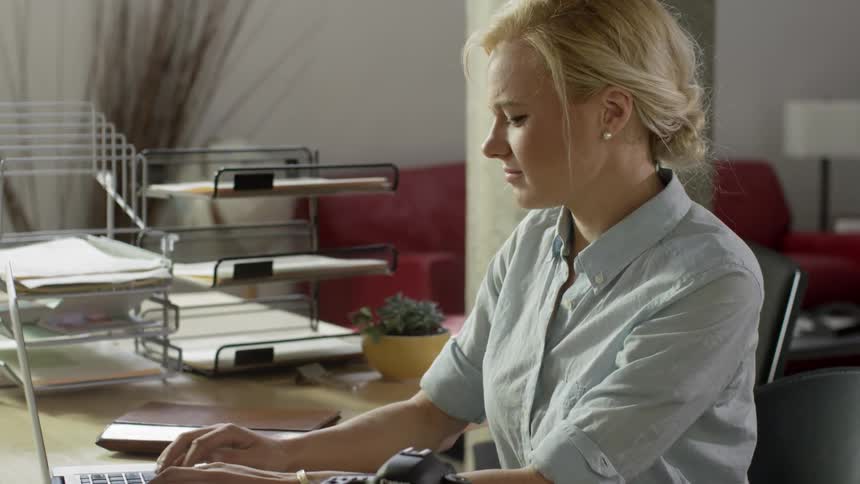 Woman sits down and opens up a laptop
