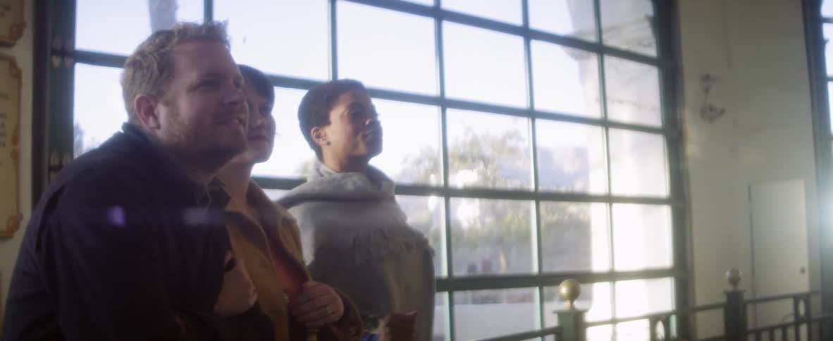 People standing by a window watching something