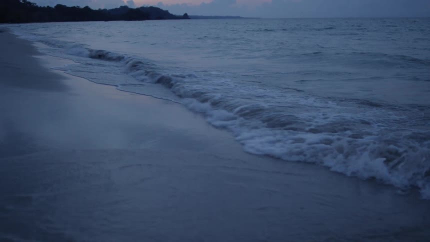 The tide flows onto the beach shore