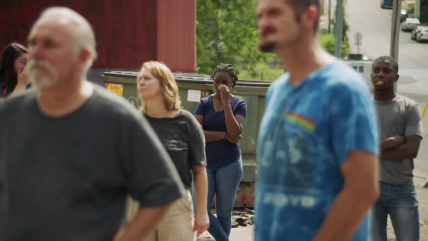 A crowd of people stand together on the street
