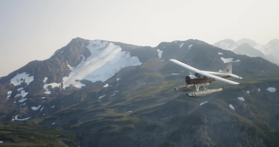 The plane slowly glides over the mountains on a foggy day