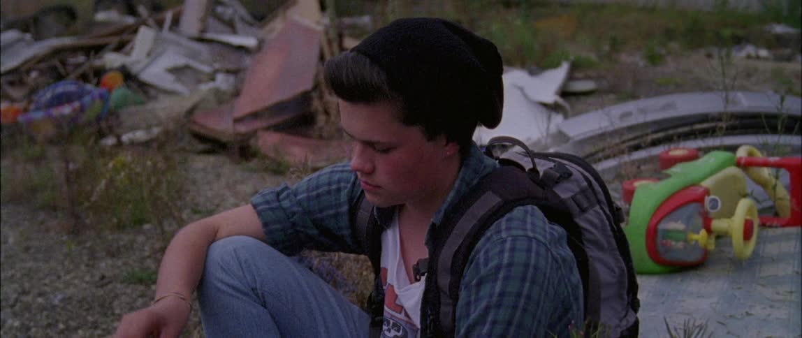 A teenager looks sad while sitting on the ground