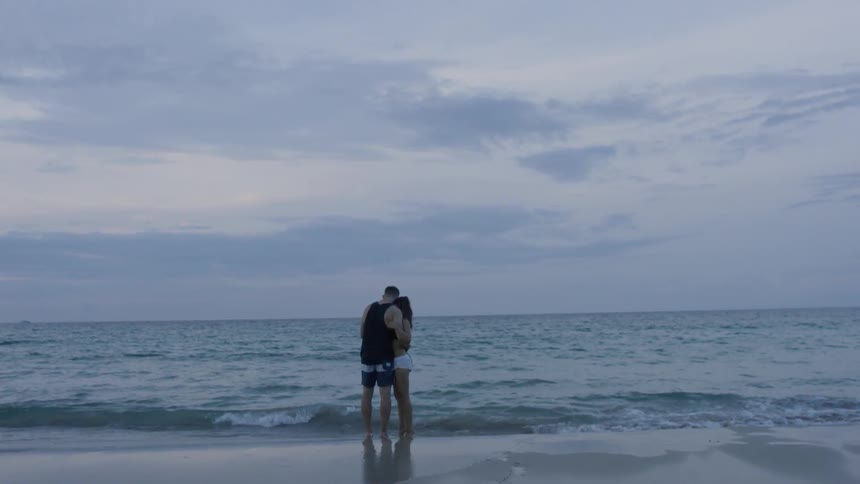 The man and woman walk to the water together