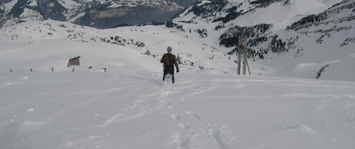 A man runs down a snow covered hill