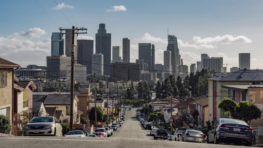 The cars drive around and away from the city ahead