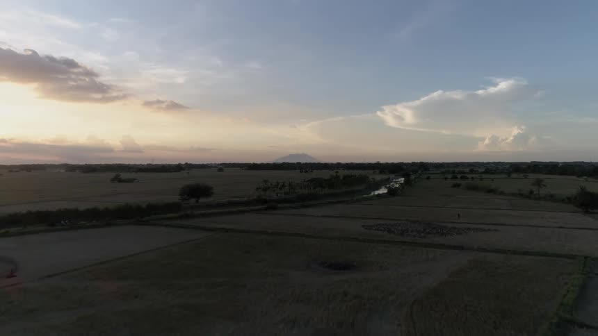 The sun is setting behind the long fields