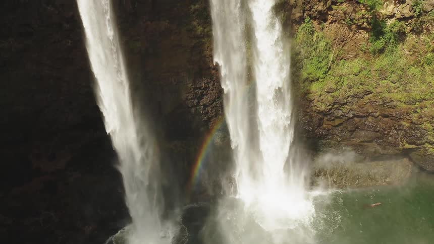 The waterfall is creating a rainbow as it pours