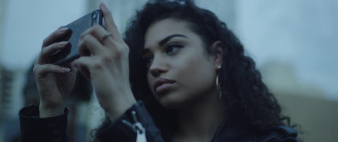 A woman looks at a smartphone outside