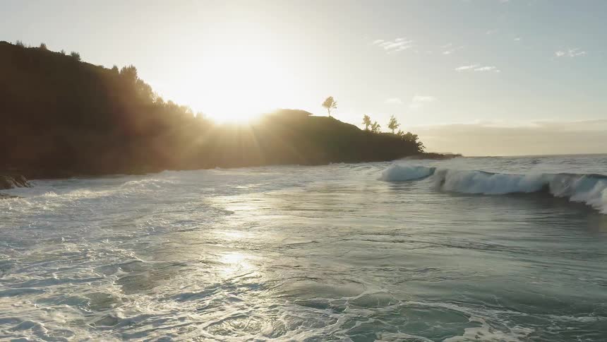 The waves strike the shore as the sun rises