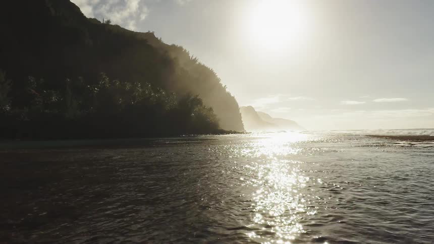 The sun shines on the ocean along the shore line