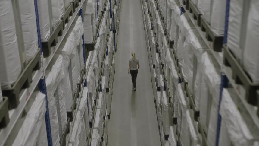 A woman walks in a warehouse