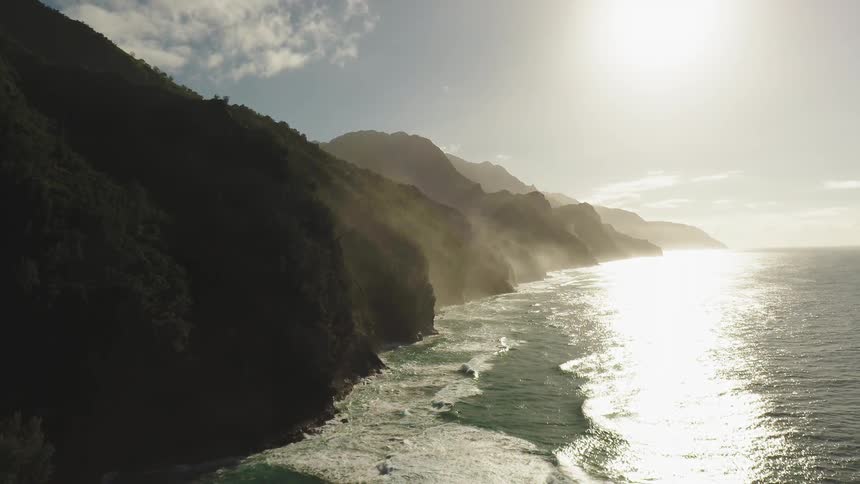 The fog rolls over the mountains near the shore