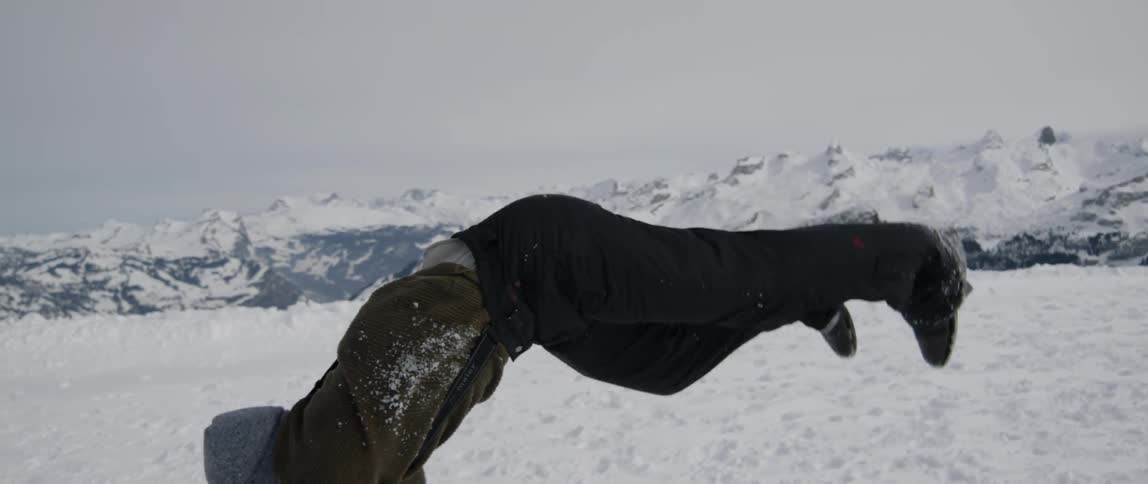 A man does a cartwheel and backflip in the snow
