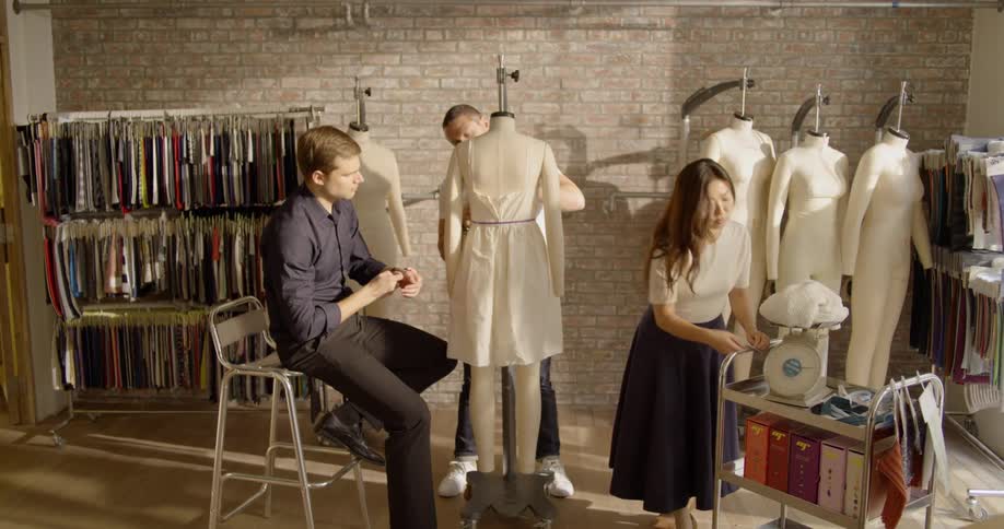 A group of people work on a piece of clothing