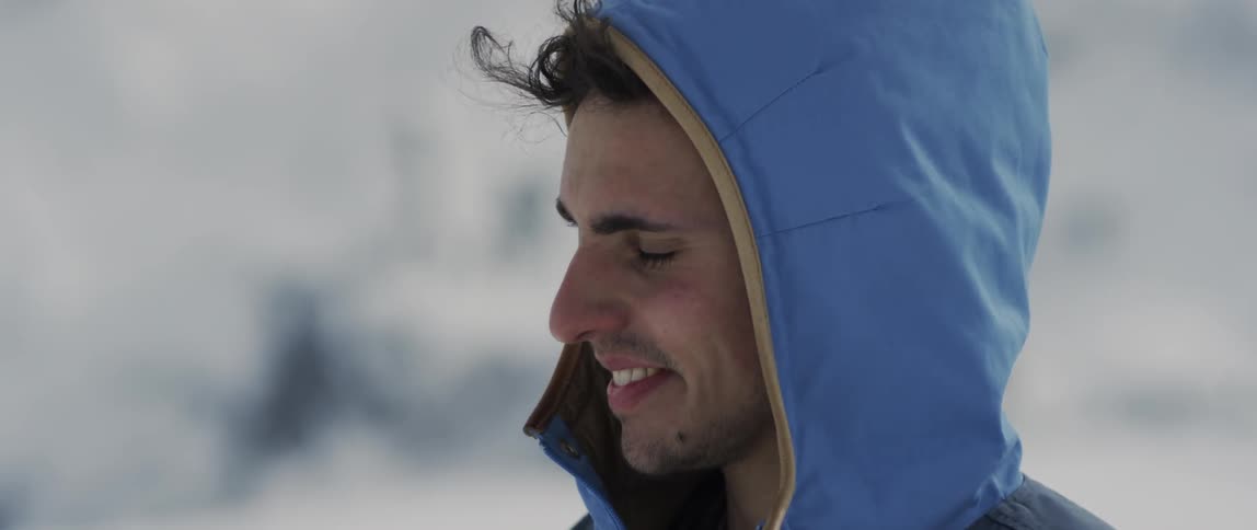 A man looks around smiling on a windy day