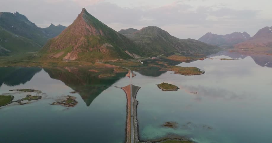 Mountains surround a body of water with a road and bridge running through it