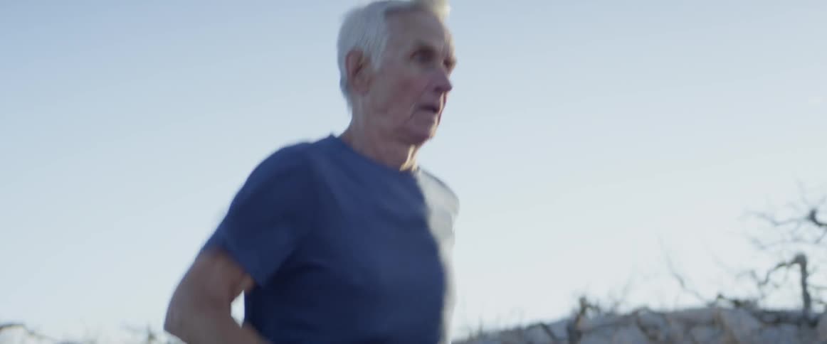 The man slowly jogs on a sunny day