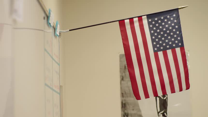 An american flag hangs in a classroom