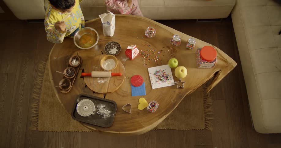 Two children work on art projects on the table