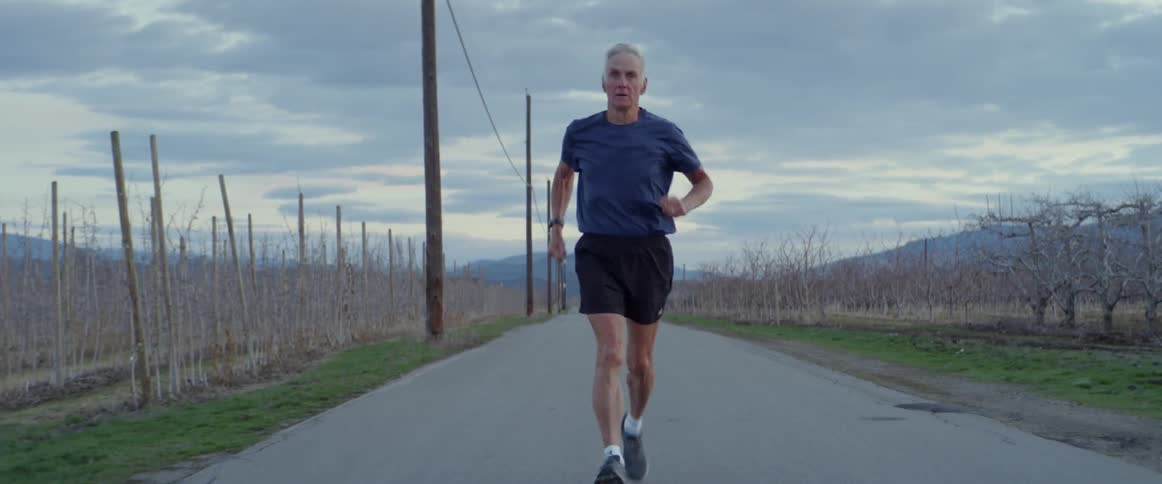 The man jogs slowly down the trail