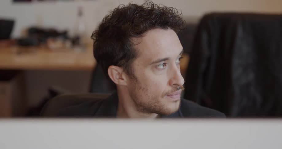 Man sits in an office and looks to his left