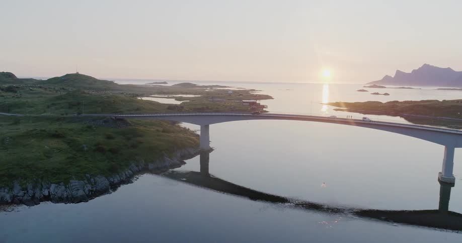 The cars travel over the bridge at sunrise