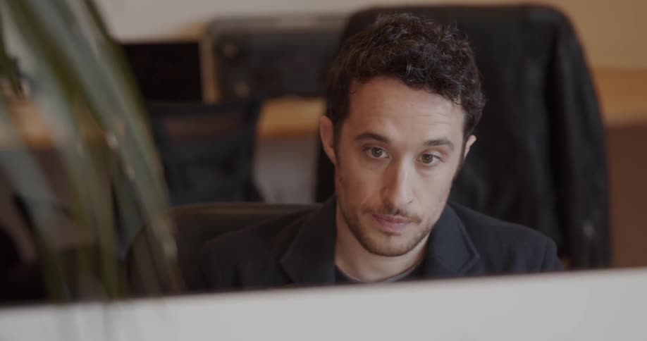 A man uses a computer at a desk
