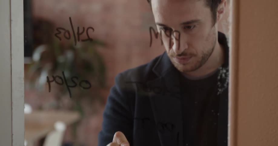 Man writes on a clear glass window
