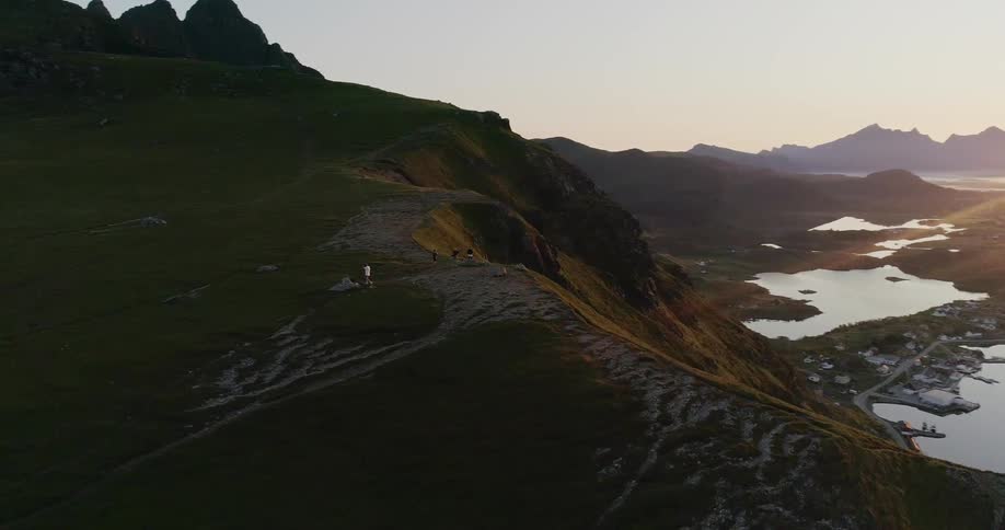 Hikers stand in mountains at sunset