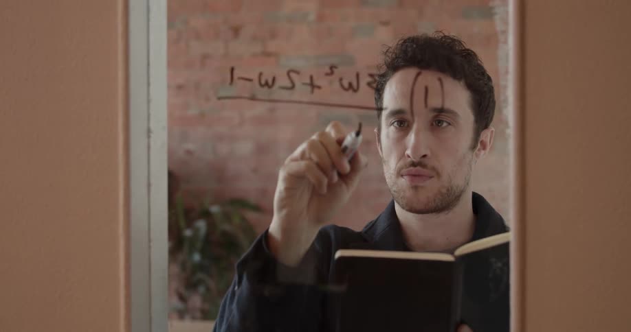 Man writes a math equation on a window
