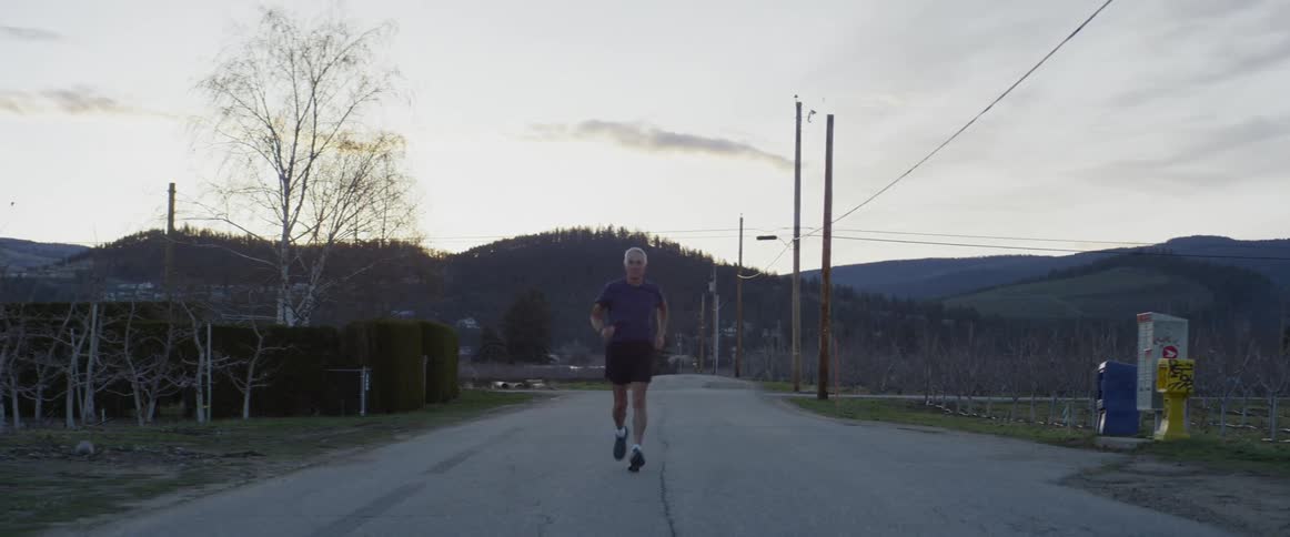 A man jogs on the road at sunrise