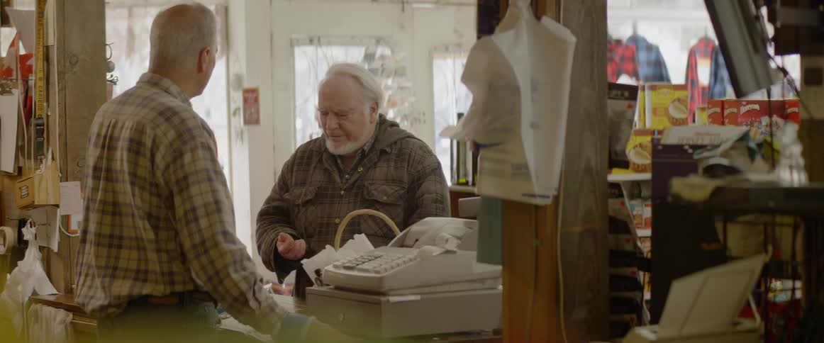 Two elderly men talking in a general store