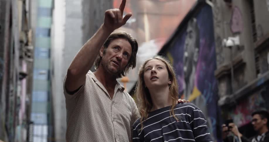 A man and child point towards some buildings