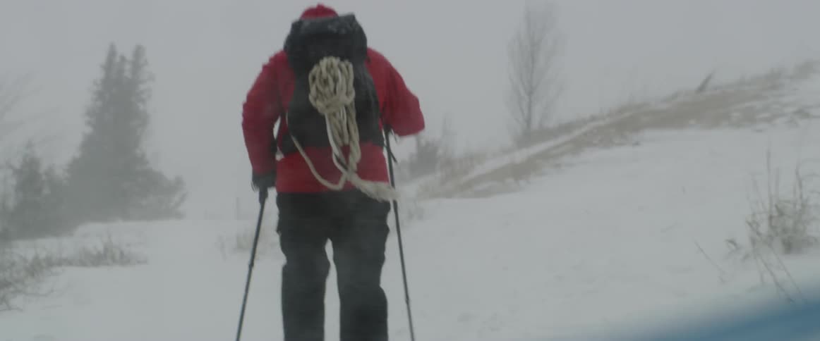 A man hikes through the snow