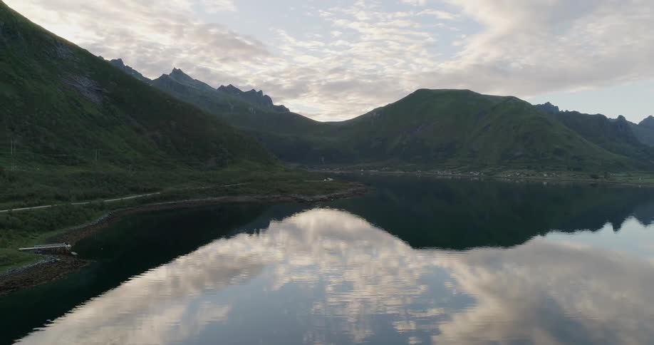 The water is calm in the lake by the mountain range